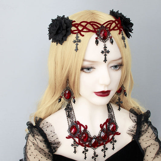 A mannequin displaying a Gothic Style Vampire Death Role Playing Cross Headdress by Maramalive™ in black attire with red jewelry.