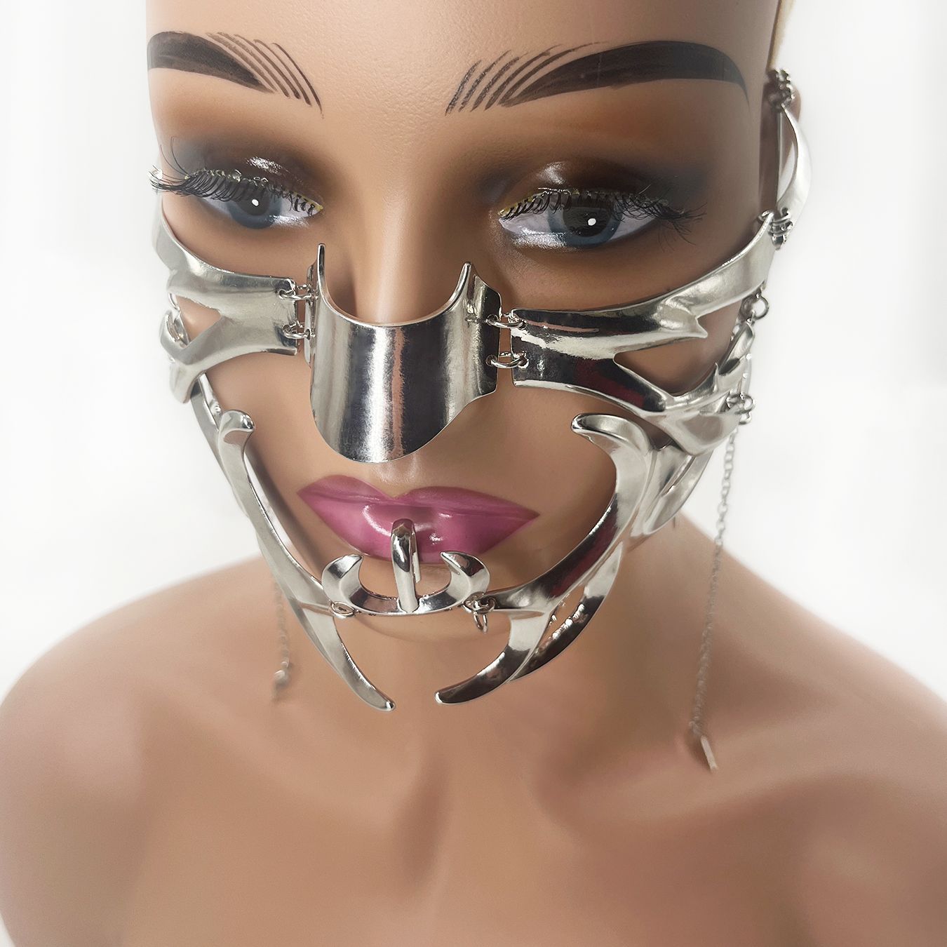 A person dressing up in a Maramalive™ Adjustable Irregular Fluid Lip Ring Mask featuring elaborate, curved designs and a dangling chain.