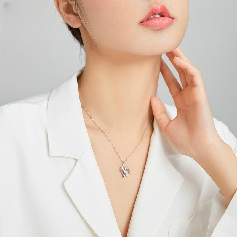 A woman wearing a white shirt and a Maramalive™ Heart-shaped Hollow Inlaid Zircon S925 Necklace.