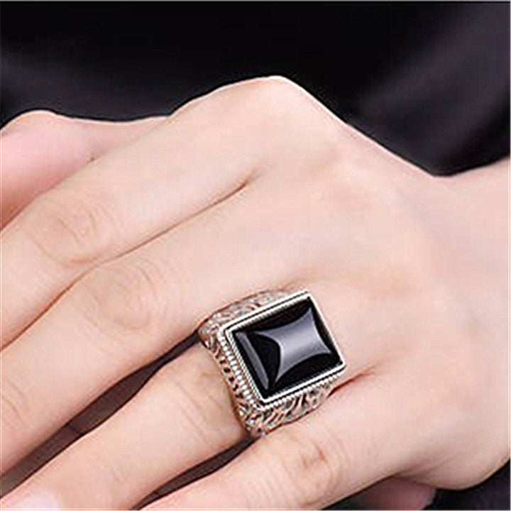 A woman's hand holding a Maramalive™ Silver Plated Black Onyx Men Ring.