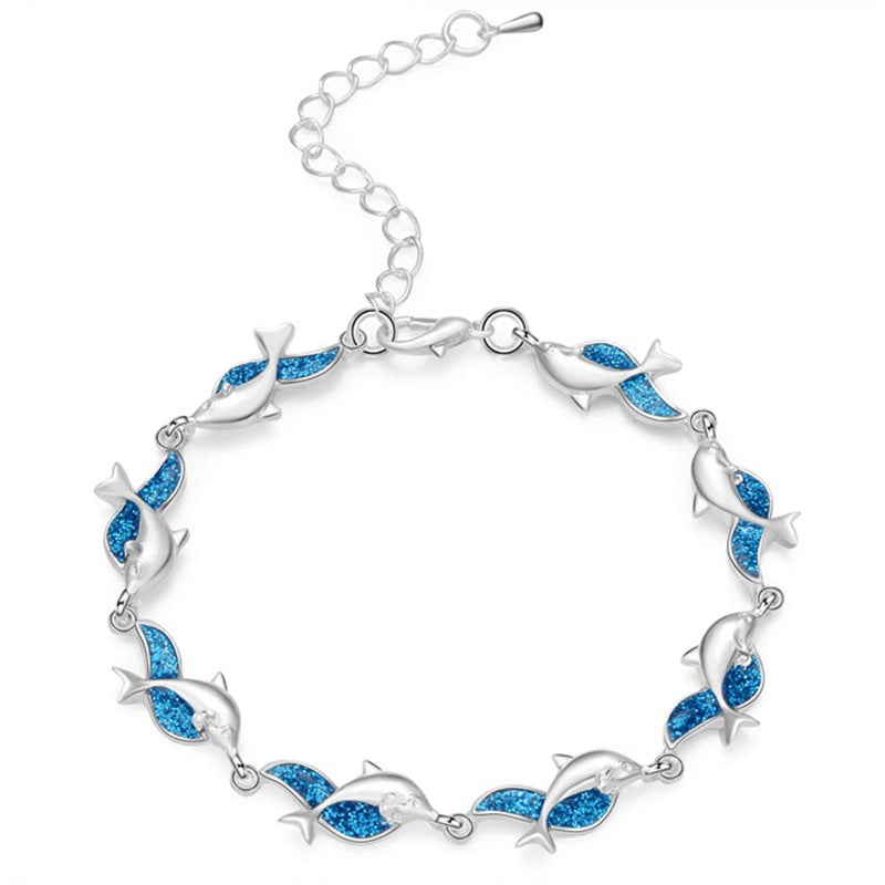 A blue and silver Women's Fashion Dolphin Epoxy Bracelet by Maramalive™ with dolphins on it.