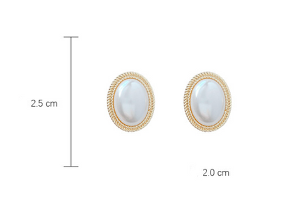 A hand holding a pair of Maramalive™ French Baroque Pearl Earrings.