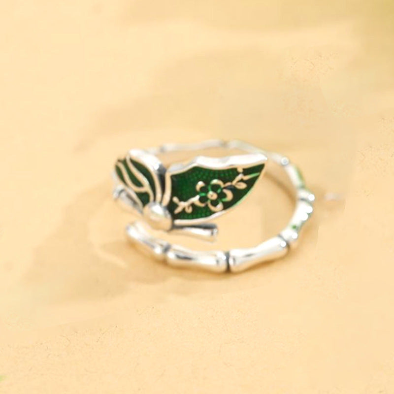 A Colorful Enamel Bamboo Butterfly Ring For Women by Maramalive™ with green leaves on it.