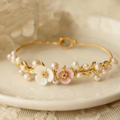 A Natural Shell Carved Pearl Handmade Bracelet Dainty and Minimalistic by Maramalive™ with pearls and flowers on a plate.