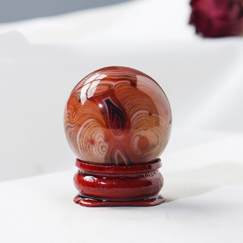 A Natural Crystal Ball Ornament on top of a Maramalive™ wooden base.