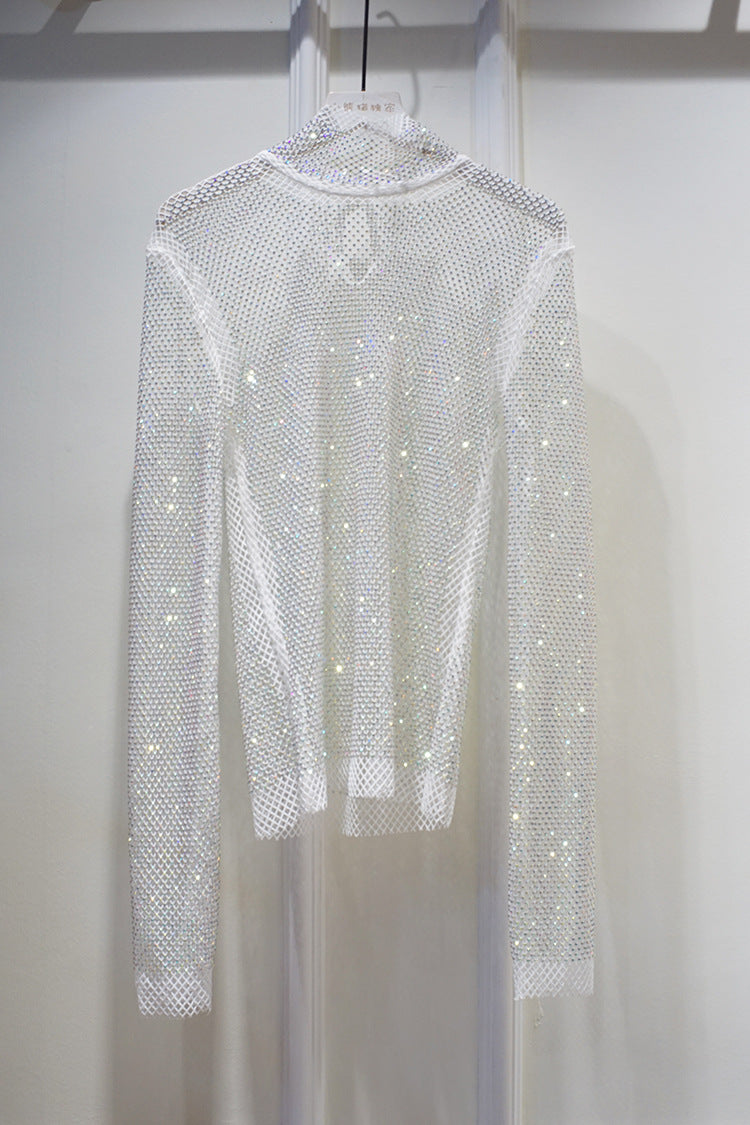 A New Crystal Rhinestone Hollow Top Starry Bright Sexy Ladies Long Sleeve See-through Net Diamond Shirt by Maramalive™ hangs on a hanger against a light-colored background.