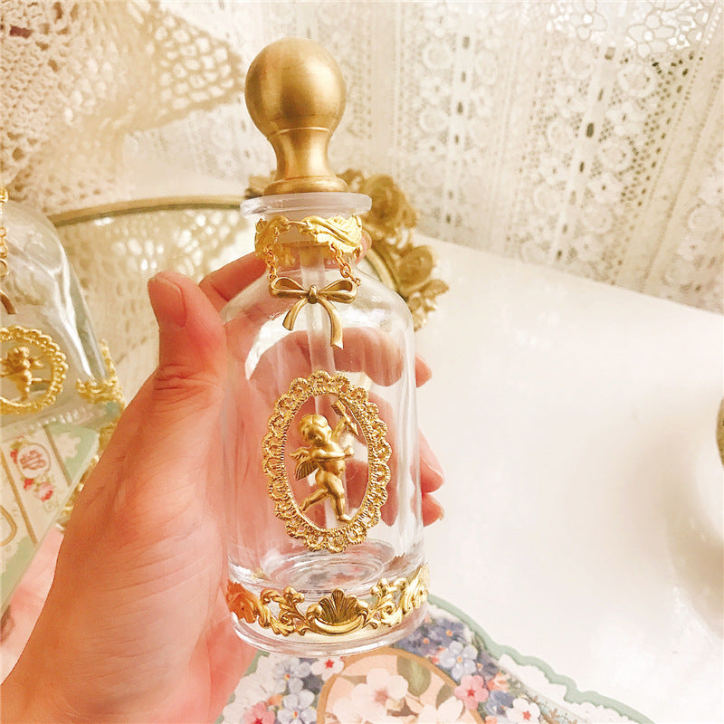 A set of Vintage French Angel Perfume Bottles on a tray with a doll on it by Maramalive™.