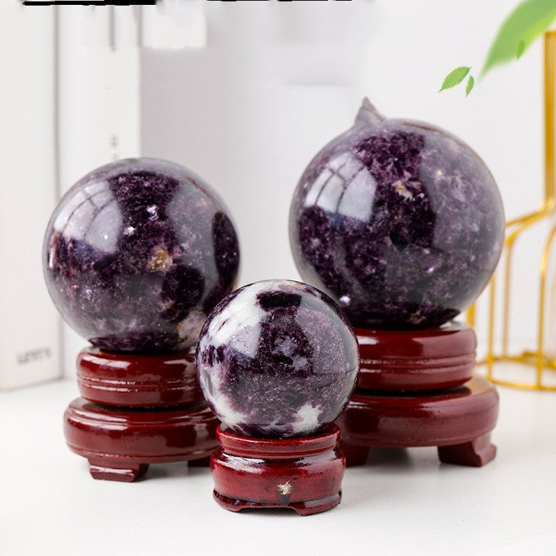 A couple of Maramalive™ Crystal Original Stone Polishing Household Crystal Ball Ornaments sitting on top of a wooden stand.