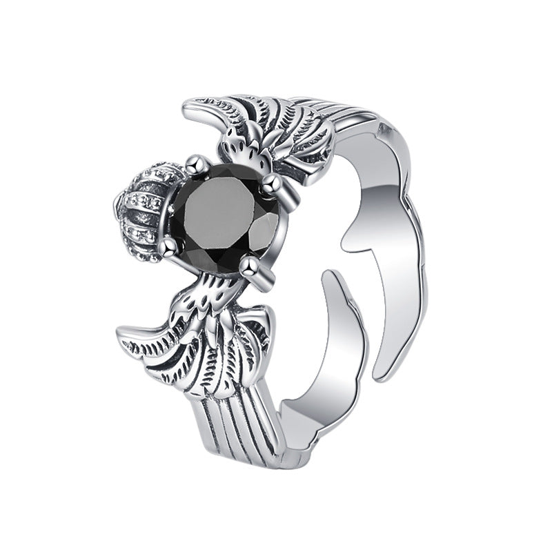 A Maramalive™ Striking Sterling Silver Crown and Wings Ring with a black stone.