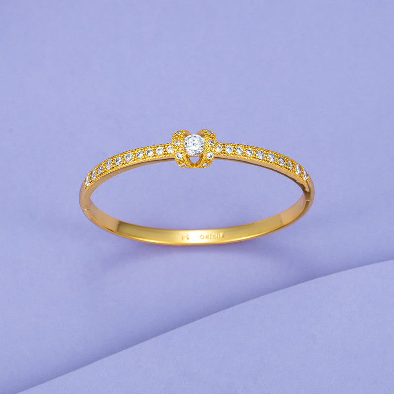 A Maramalive™ Brass Gold-plated Bracelet with diamonds on a purple background.