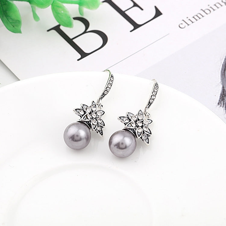 A pair of Maramalive™ gray pearl earrings on a white background.