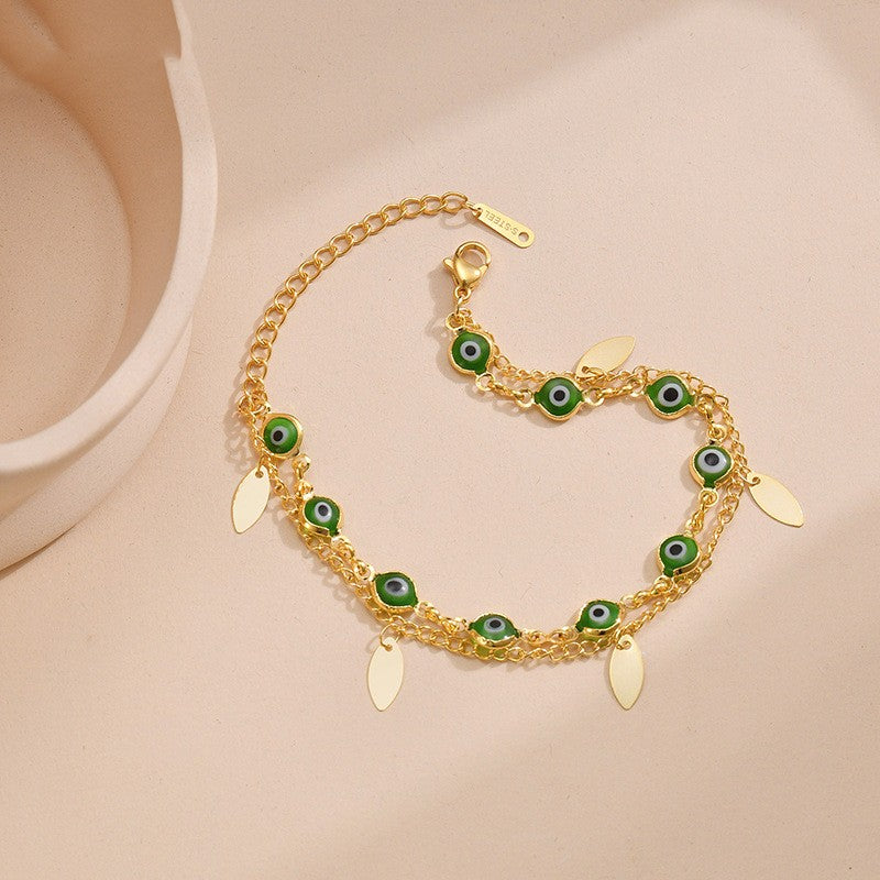 A Titanium Gold Oval Twin Bracelet - Elegant & Durable 14K Gold adorned with green eyes and leaves made by Maramalive™.