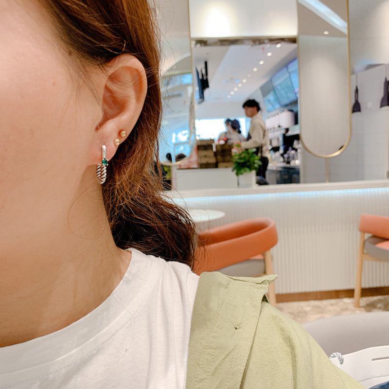 A woman wearing a white shirt and a pair of Maramalive™ Geometric Earrings.