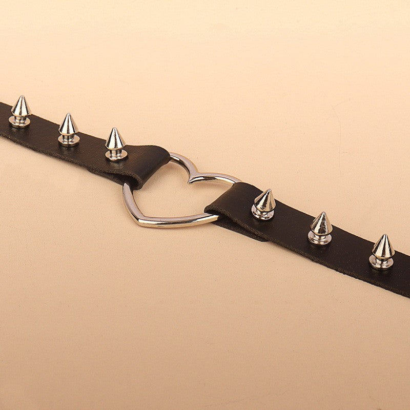 Punk Faux Leather Choker - Gothic Spiked Heart Necklace Black stretched out on beige background