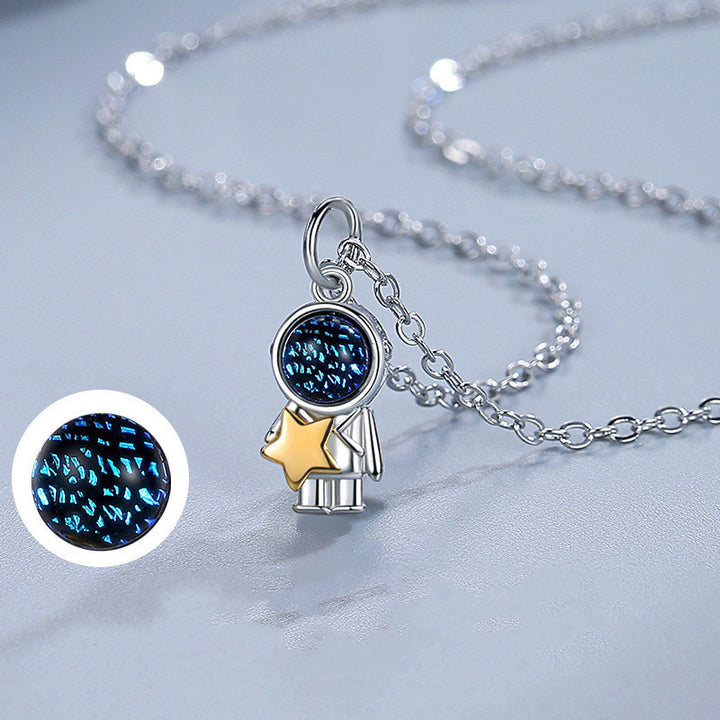 Two people holding hands and holding a Fashionable Spaceman Pendant Necklace from Maramalive™.