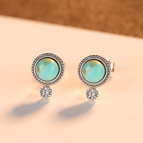 A woman's ear with Maramalive™ Small Turquoise Stud Earrings - Retro Fashion.