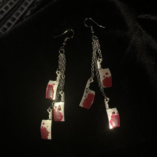 A pair of Drop Dead Gorgeous for Halloween Kitchen Knife Earrings by Maramalive™ with red blood on them.