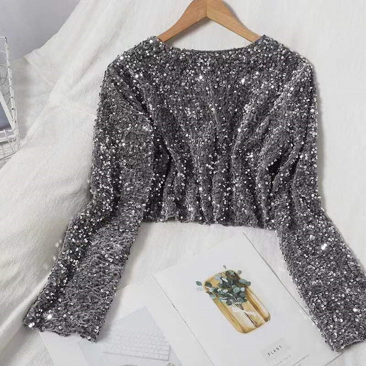 A fashionista's bed adorned with two Shimmery Sequined Crop Tops for dazzling style, including a luxurious Maramalive™ Cashmere Sequined Crop Top.