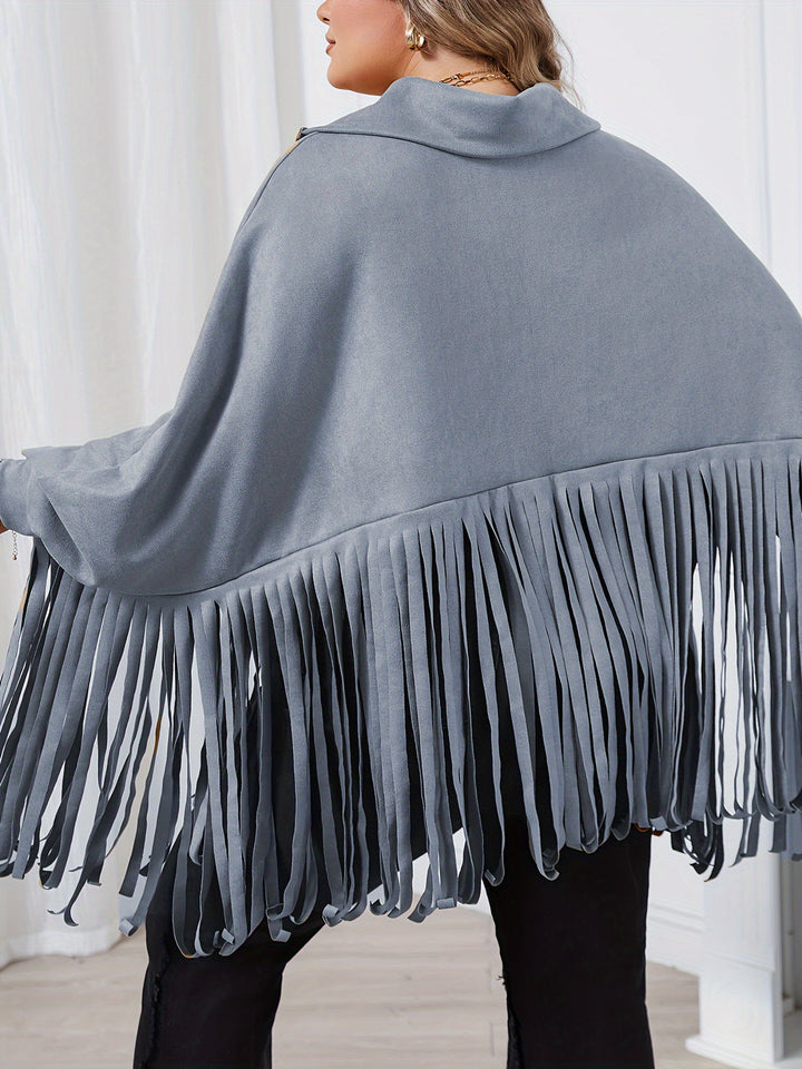 A person wearing a gray Maramalive™ Plus Size Trendy Top, Women's Plus Solid Batwing Sleeve Mock Neck Fringe Trim Cloak Top, seen from the back, standing in a room with white curtains—a perfect look for Fall/Winter.