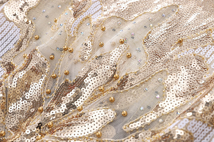 Close-up of a semi-transparent fabric, adorned with shimmering gold sequins, beads, and intricate embroidery, showcasing an elegant style perfect for crafting the Maramalive™ Petal Long Sleeve Beaded Sequins Slimming Lace Versatile Mesh Plus Size Top.