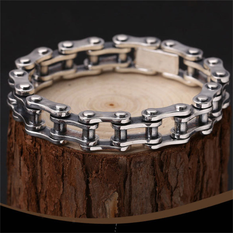 A Sterling Silver Bicycle Chain Bracelet - Punk Style from Maramalive™, on top of a tree stump.