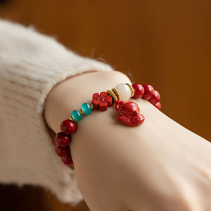 A woman wearing a Maramalive™ Women's Fashion Simple Red Flower Fox Bracelet.