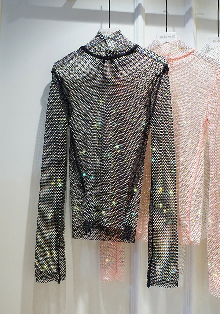 A Maramalive™ New Crystal Rhinestone Hollow Top Starry Bright Sexy Ladies Long Sleeve See-through Net Diamond Shirt hangs elegantly on a rack in the clothing store.