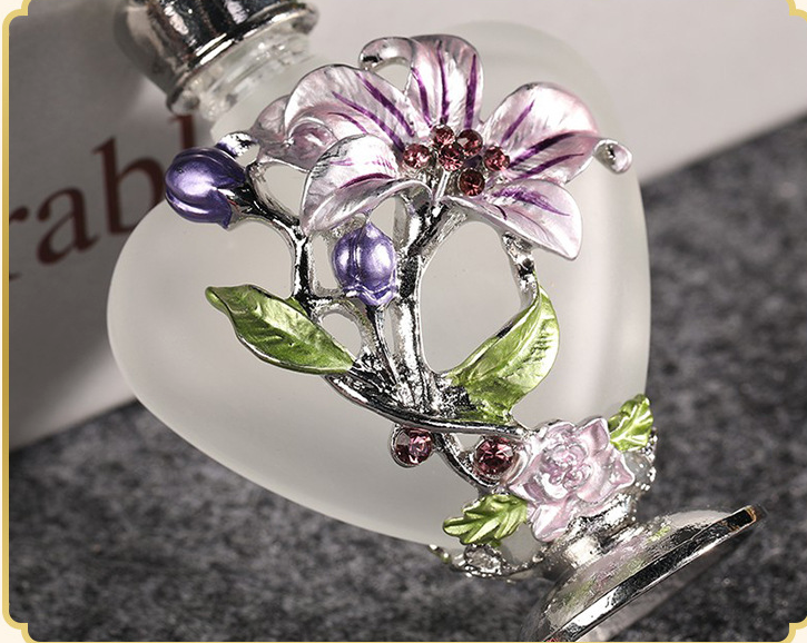 A vintage Maramalive™ Orchid Perfume Glass Bottle 10ML adorned with delicate flowers, crafted in a charming heart shape.