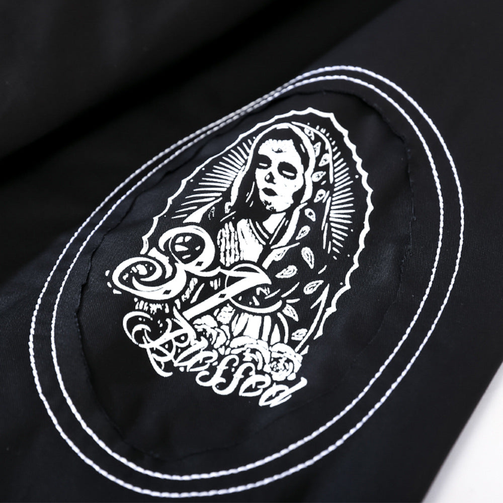 Black fabric with a white embroidered design depicting a religious figure, likely the Virgin Mary, framed in an oval shape with the words "Be Blessed" written below. This versatile Maramalive™ Men's printed long-sleeve shirt | Men's dress shirt is perfect for any occasion.