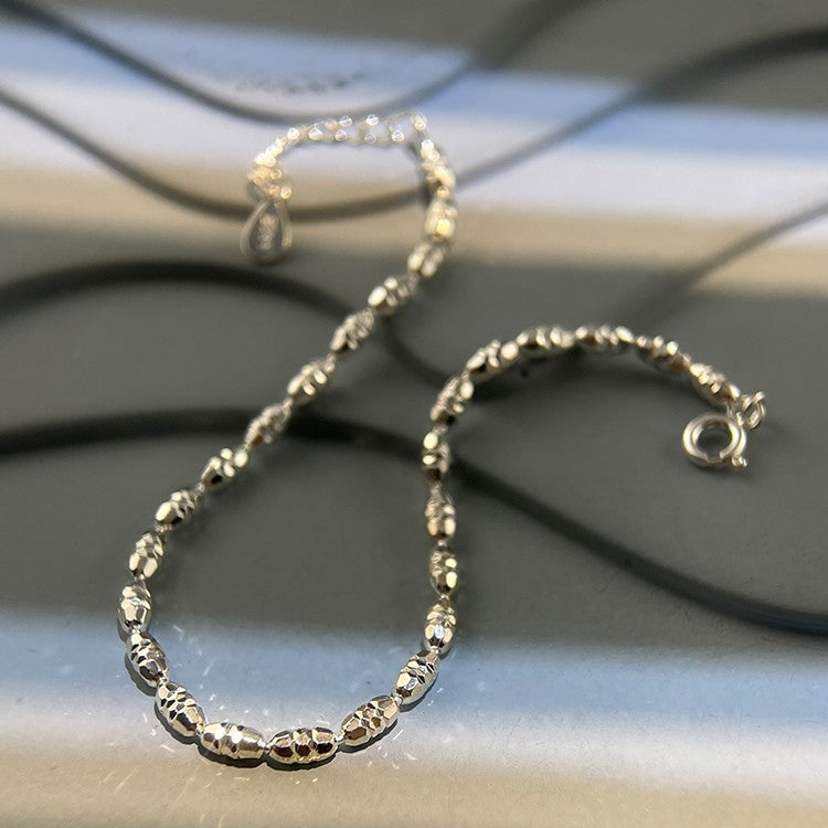 A woman's wrist with two "Geometric Cut Rice Ball Bracelets - Minimalist 925 Sterling Silver Jewelry" by Maramalive™ on it.