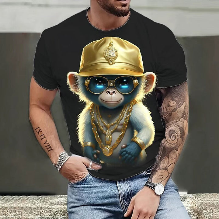 A person wearing a Maramalive™ 3D Printed Men's Crew Neck Casual T-shirt with a graphic of a small monkey dressed in a gold hat, sunglasses, and multiple gold chains. The person's left arm, adorned with numerous tattoos, rests casually on their jeans pocket.