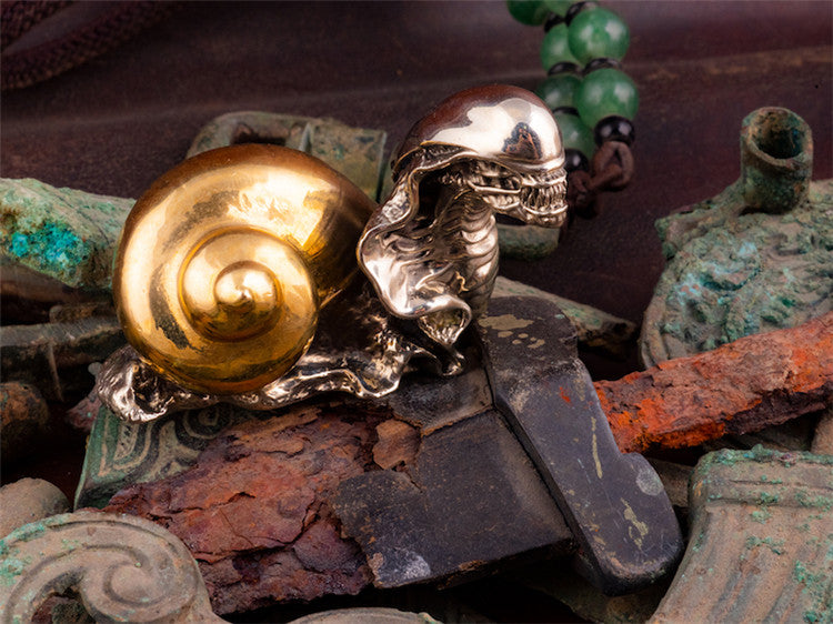 A Maramalive™ Bronze Two-color Study Steampunk Ornament snail sitting on top of a wooden box.