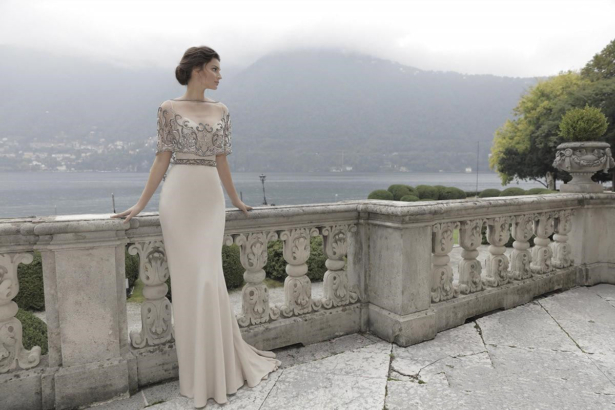 A woman in a Maramalive™ wedding dress is posing on a balcony overlooking a lake.