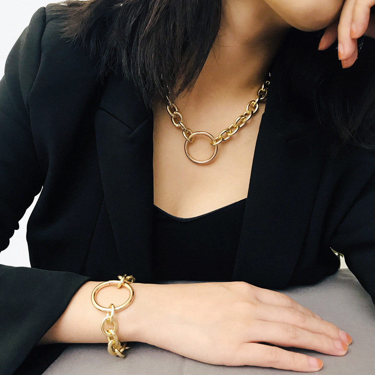 A woman wearing a black jacket and a Maramalive™ Personality Punk Exaggerated Metal Necklace Necklace Simple Geometric Circle Retro Necklace Bracelet Set bracelet.