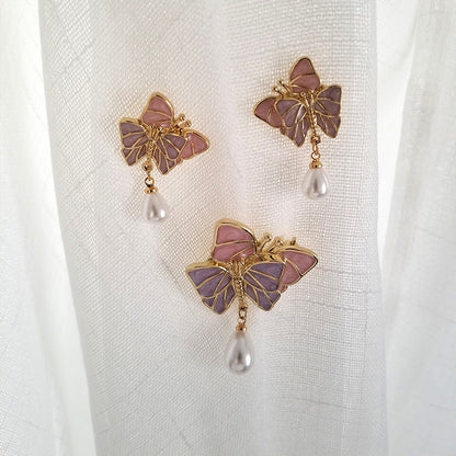A person holding a Maramalive™ Butterfly Brooch Silk Scarf Button with Enamel Waist Closing Pin.