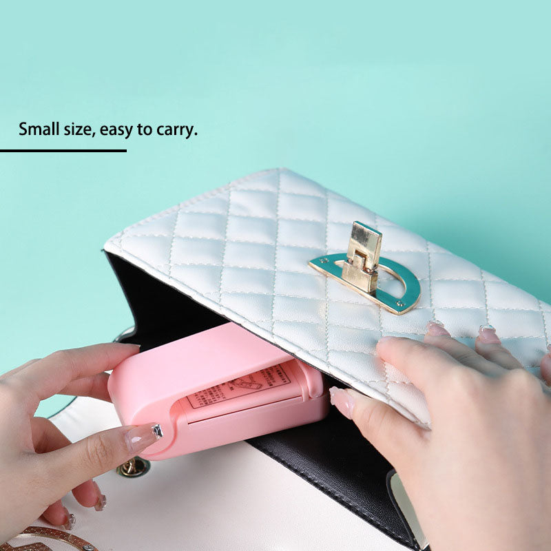A pink and white Mini Sealing Machine charger sitting on top of a green surface, made by Maramalive™.