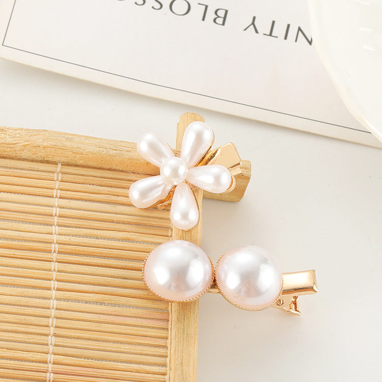 A set of Pearl Bow Hair Clips by Maramalive™ on a magazine.