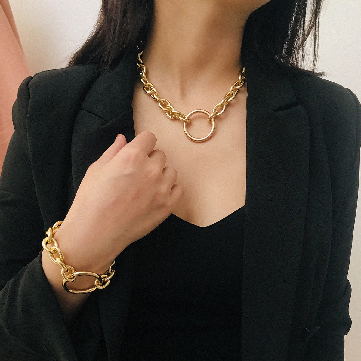 A woman wearing a black jacket and a Maramalive™ Personality Punk Exaggerated Metal Necklace Necklace Simple Geometric Circle Retro Necklace Bracelet Set bracelet.