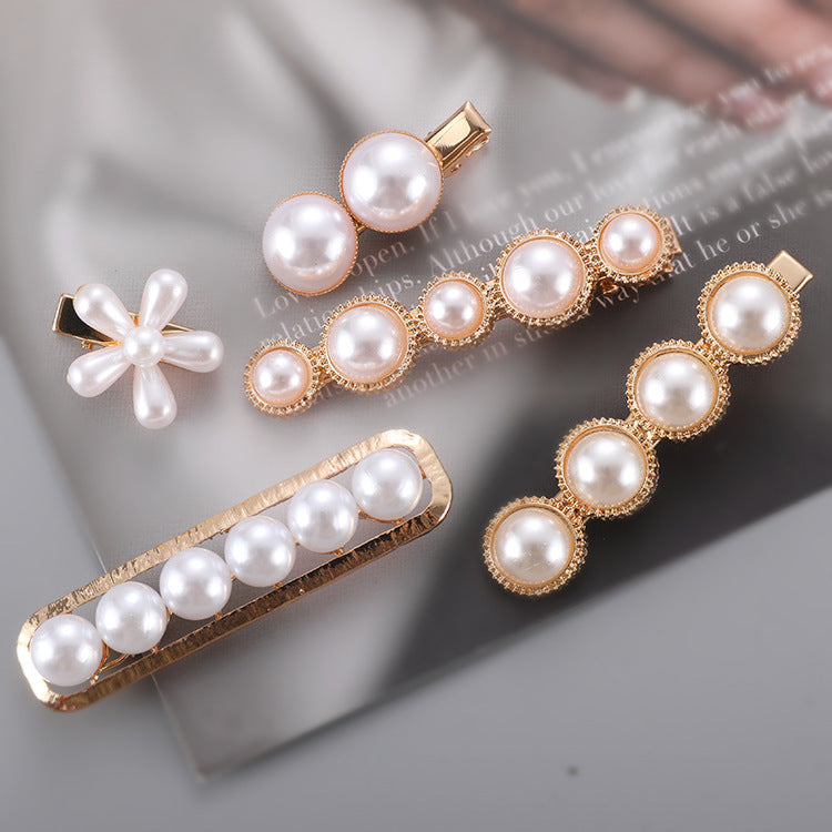A set of Pearl Bow Hair Clips by Maramalive™ on a magazine.