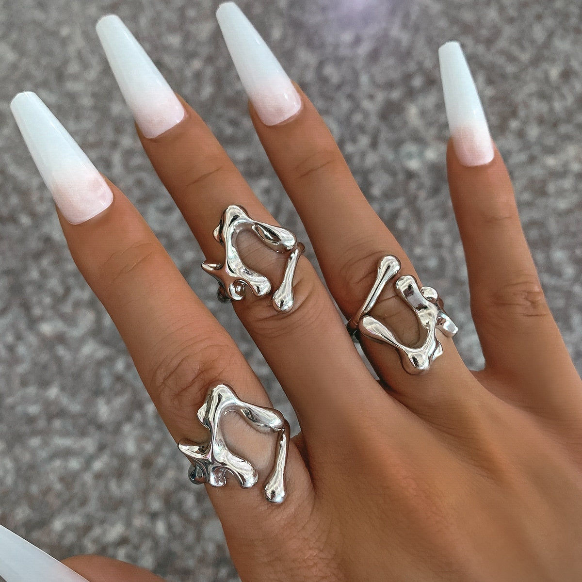 A woman's hand with white nails and a Maramalive™ Geometric Ring.