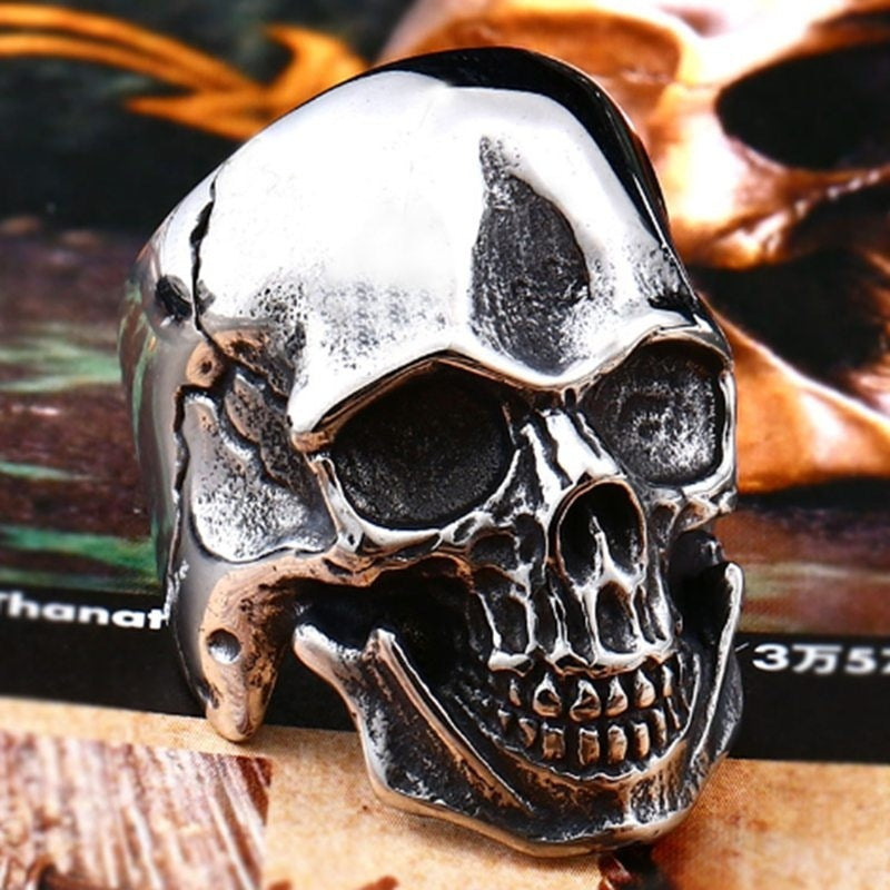 An Express Your Inner Rebel with this Stunning Punk Skull Ring by Maramalive™ on top of a book.